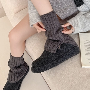 Macro detail of dark grey ribbed knit leg warmers with thick thermal wool texture
