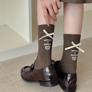 Brown knit socks with ribbon bow and heart embroidery paired with leather loafers