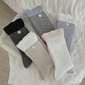 Detail of 5-pack crew socks featuring lace trim and white flower buttons in various colors