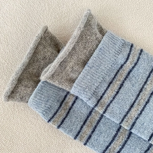 Détail de chaussettes en maille vintage à rayures avec bords roulés et texture laine