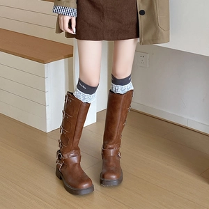 Detail of dark brown vintage knee-high boots with multi-buckle straps and rubber platform