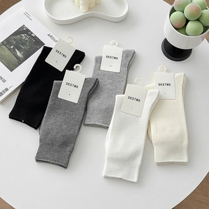 Détail de cinq paires de chaussettes en coton côtelé aux tons neutres avec logo épuré