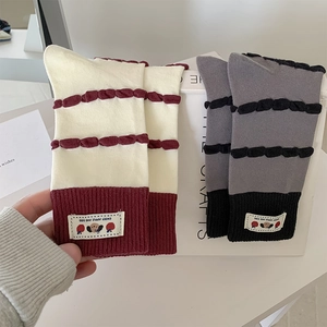 Detailed knit texture of striped socks with cute cartoon patches and ribbed cuffs