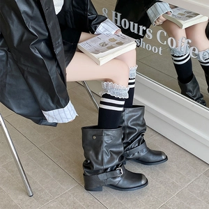 Close-up of black calf socks with white stripes, delicate lace trim and embroidery detail