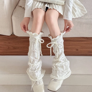 White knit leg warmers with pointelle patterns and bow tie ribbons in balletcore style