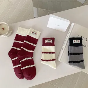 Three pairs of sweet striped mid-calf socks in red, white and grey with cute labels