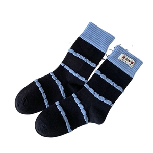 Cute Korean style black crew socks with blue stripes, ribbed cuffs and a cartoon label