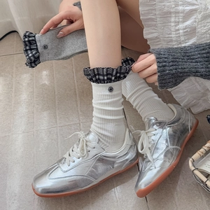 Silver metallic sneakers with white ribbed ruffle socks featuring plaid lace trim