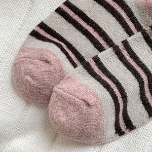 Detailed macro view of pink and grey striped wool knit socks with soft winter texture