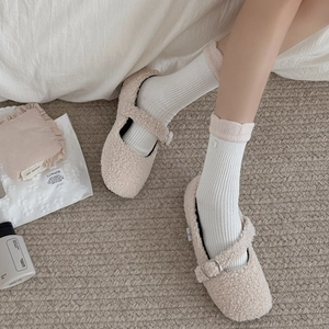 Close-up of cozy beige fleece Mary Jane shoes paired with white ribbed cotton socks