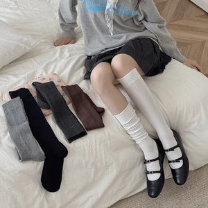 Close-up of ribbed knit knee high socks in ivory, grey, black, and coffee brown colors