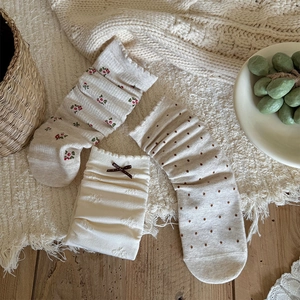 Detailed texture of retro floral and polka dot knit socks with a brown bow detail