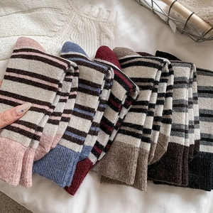 Detail view of colorful striped wool mid-calf socks with soft knitted textures and warm tones