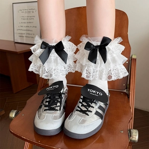 Detailed white lace leg warmers with black satin bows for Lolita and JK style outfits