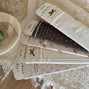 Detail of five-pair set of mid-calf socks with floral patterns and bow accents