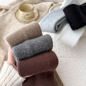 Detail view of thick ribbed knit leg warmers in various neutral colors for winter