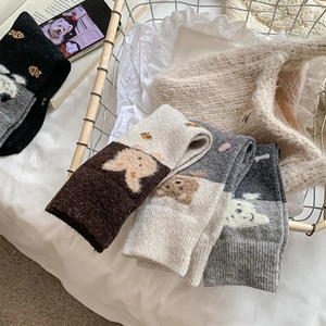 Détail du tricot de chaussettes d'hiver thermiques avec motifs d'ours et de carottes