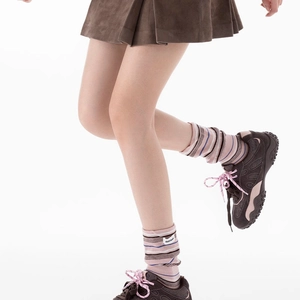 Détail de chaussettes rayées roses et marron avec étiquette blanche et maille côtelée
