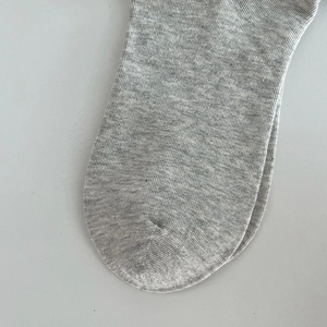 Detailed macro view of seamless toe stitching and ribbed knit texture on gray cotton socks