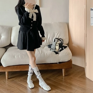 Detail of white calf socks with black bows and vertical stripes on ballet style outfit