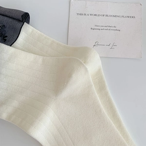 Detail von cremefarbenen Rippstrick-Socken im Ballett-Stil mit Textur und Rollsaum