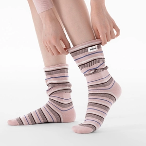 Détail de chaussettes rayées en tricot avec étiquette 'OUR Likable' et bord extensible