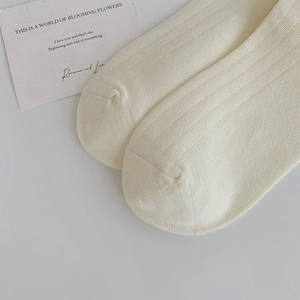 Details von cremeweißen Rippstricksocken mit weicher Textur und feinen Nähten