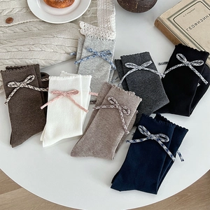 Detail of cotton crew socks with ruffled edges and plaid bow in various colors