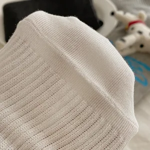 Detailed macro view of white ribbed knit fabric texture on cotton knee-high socks