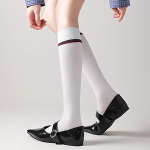 Detail of white knee-high socks with red and blue stripes and ribbed cotton texture