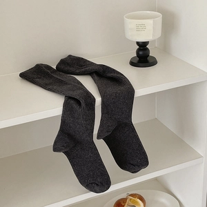 Detailed texture of dark grey ribbed knit knee-high socks showing vertical pattern