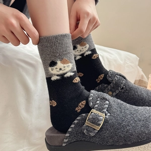 Détail de motifs chat et poisson sur des chaussettes épaisses bicolores noires et grises