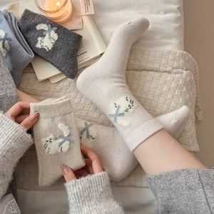 Close-up of cozy knitted wool socks with 3D flocked cat and bow details for women