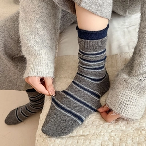 Détail de la texture des chaussettes rayées grises avec bords-côtes élastiques portées