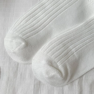 Detailed close-up showing the vertical knit texture and reinforced toe of white cotton socks
