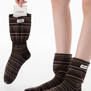 Détail de chaussettes rayées avec écusson logo tissé et emballage en carton