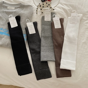 Detailed texture of cotton calf socks in five neutral colors on white bedding