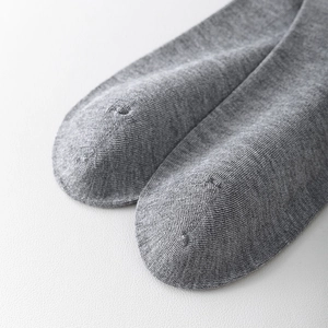 Detailed macro view of the smooth toe seams and grey knitted texture of high calf socks