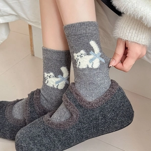 Detailed knit of grey wool socks with cat pattern and light blue bow tie detail