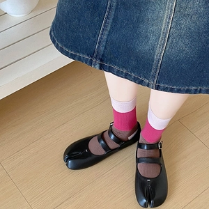 Detail of black Tabi Mary Jane shoes with double straps and colorful cotton crew socks