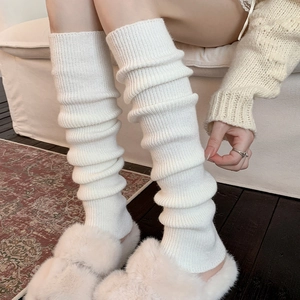 Thick white knit leg warmers with vertical ribbed texture for a cozy winter look