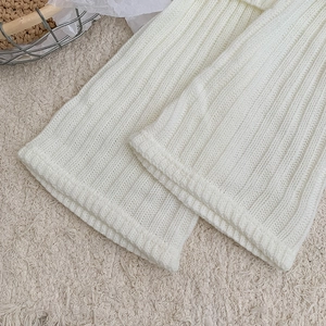 Detailed close-up of ivory ribbed knit leg warmer showing soft texture and pattern