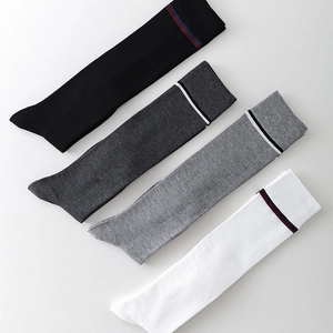 Detailed knit texture of four pair cotton knee high socks with striped ribbed cuffs