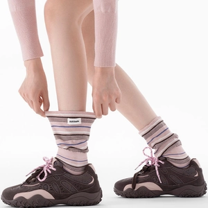Chaussettes mi-hautes rayées style preppy rose et marron avec baskets vintage sur fond blanc