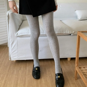 Detail showing grey ribbed knit leggings with vertical stripe texture for autumn and winter