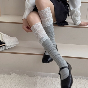 Detail of light grey ribbed knee-high socks with delicate white lace trim on model