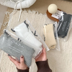Detail of four-color knit socks with black bows and individual zipper packaging