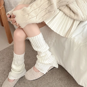 Detail of creamy knit leg warmer showing ribbed texture and thick winter fabric
