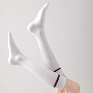 Detailed knit texture of white knee-high socks with classic red and blue stripes