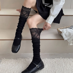 Close-up of black lace trim and vertical striped texture on ballet style calf socks